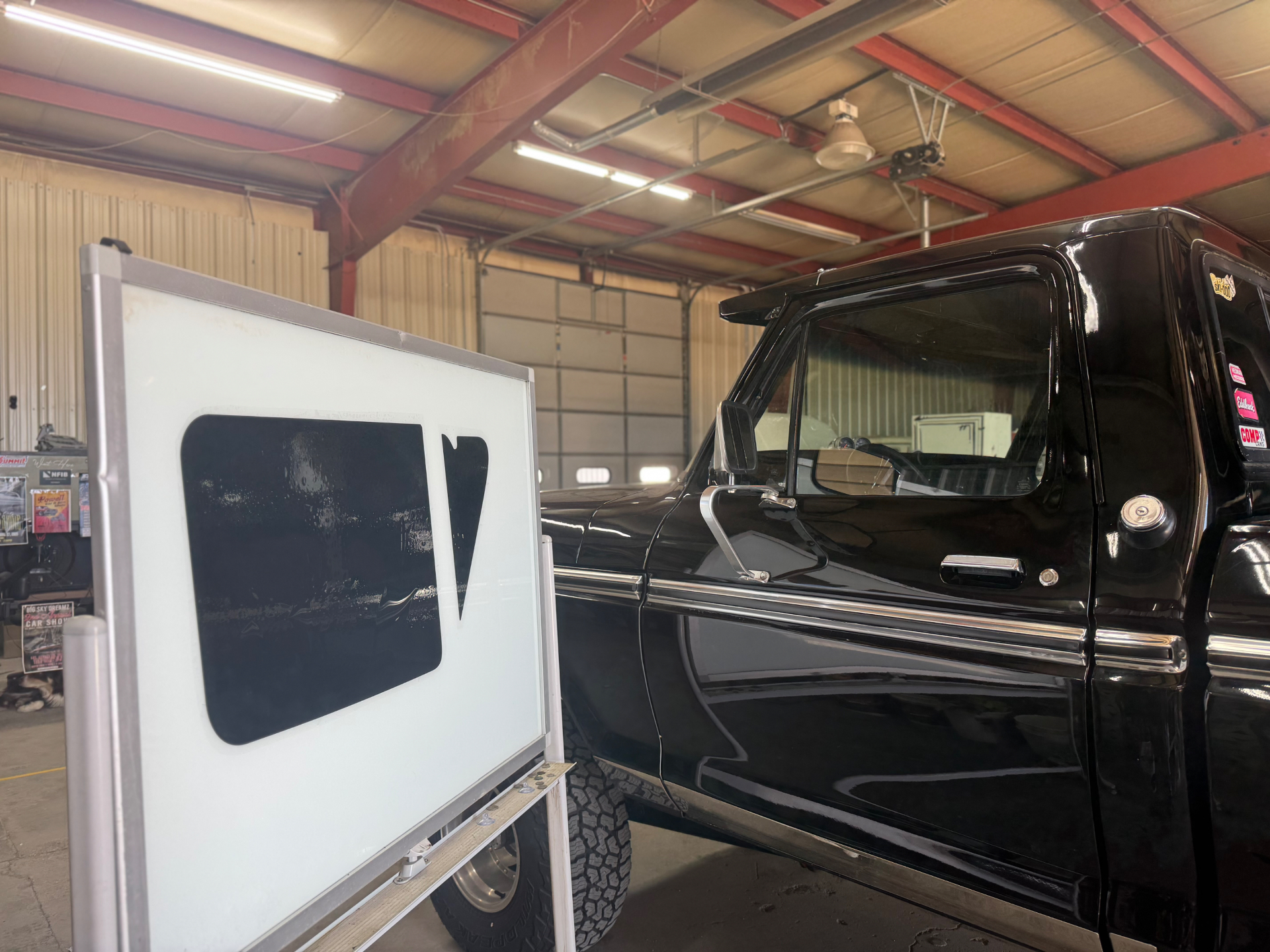 Classic black truck beside window tint film inside the shop
