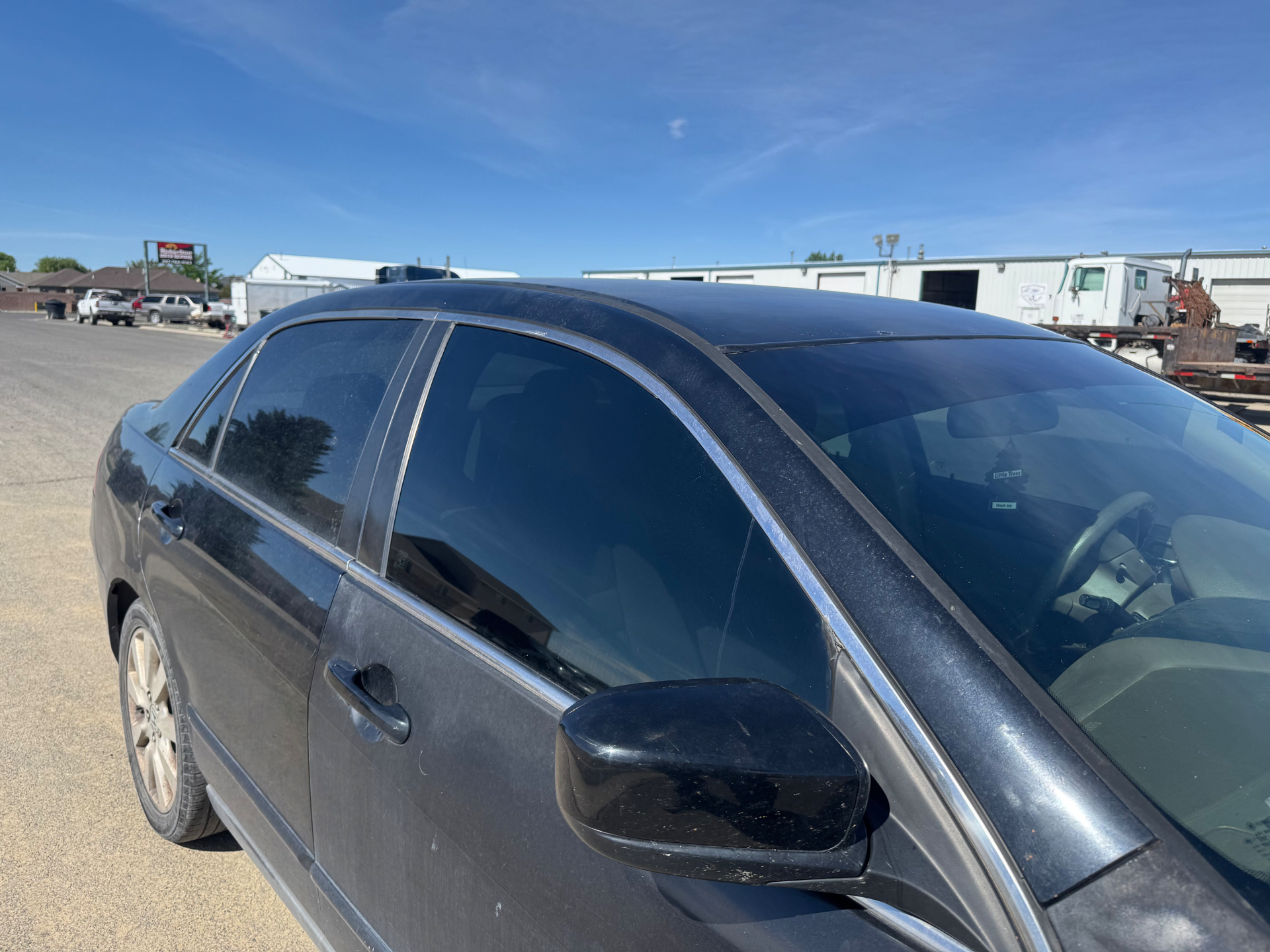 Black sedan with freshly tinted side windows outdoors