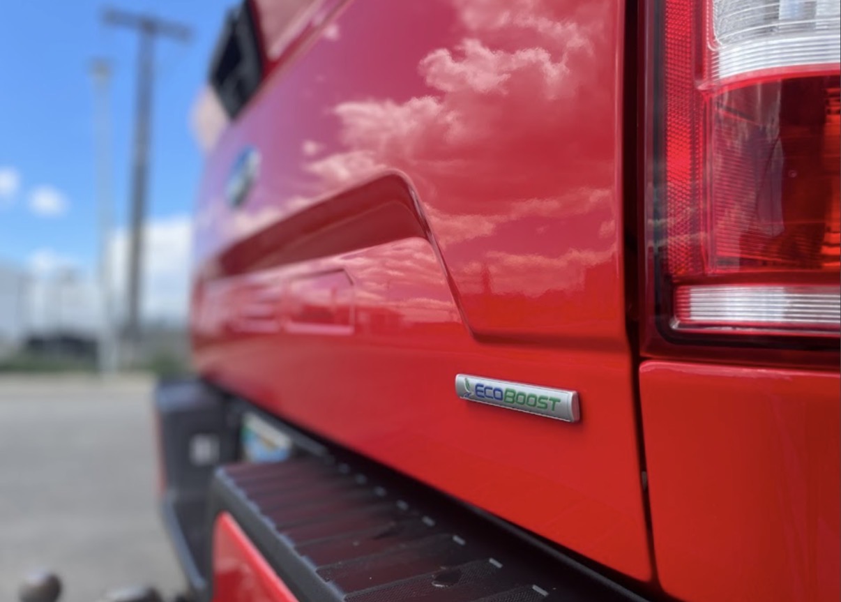 Red Ford EcoBoost tailgate with mirror-clear sky reflection after ceramic coating